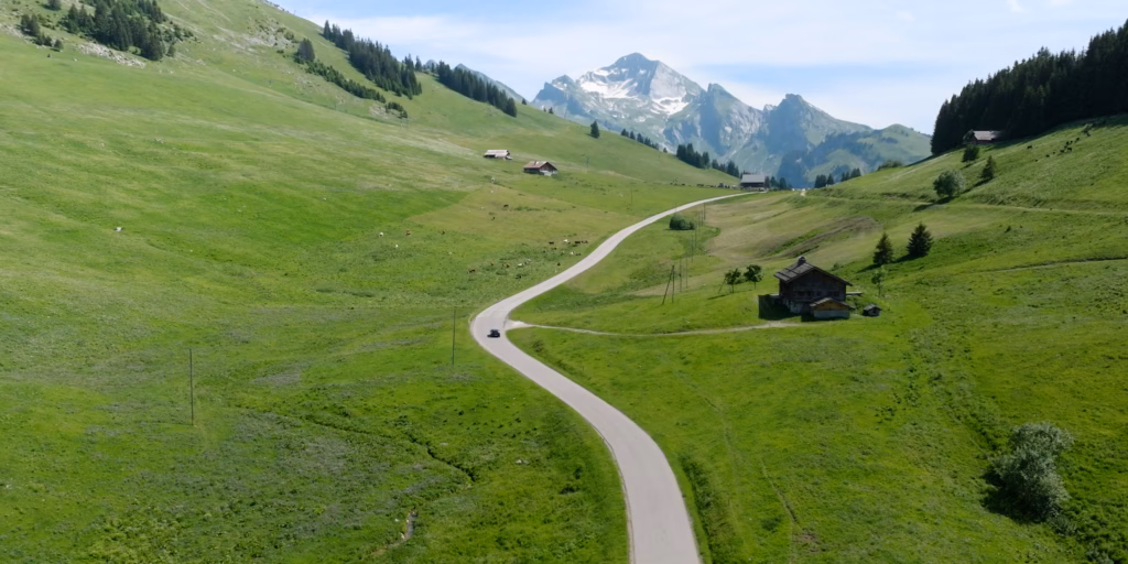 Extrait film de marque, plan drone avec une voiture au milieu des montagnes