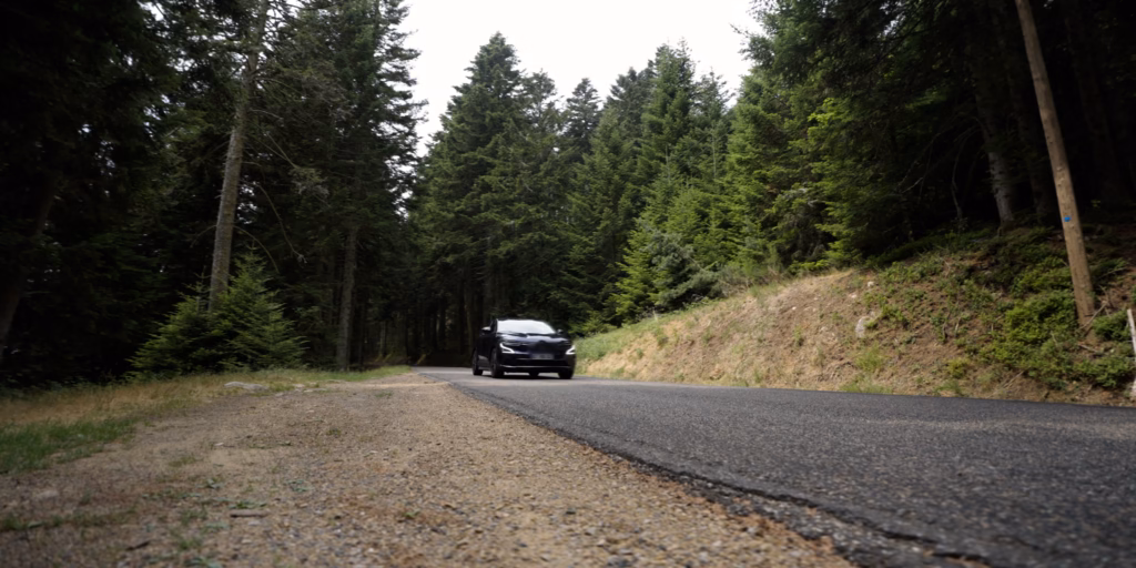 Voiture électrique sur une route bordée d’arbres